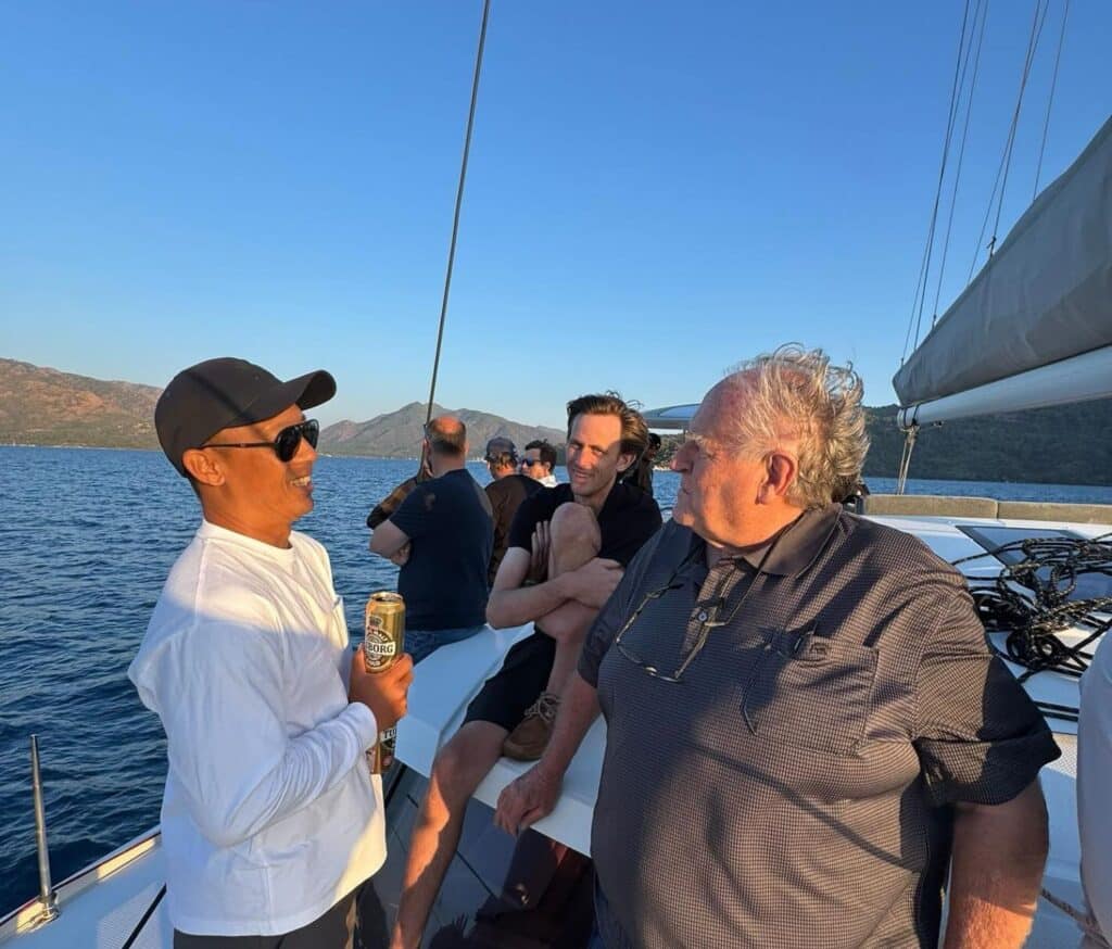 UK Sailmakers colleagues chatting on a yacht's deck at sunset