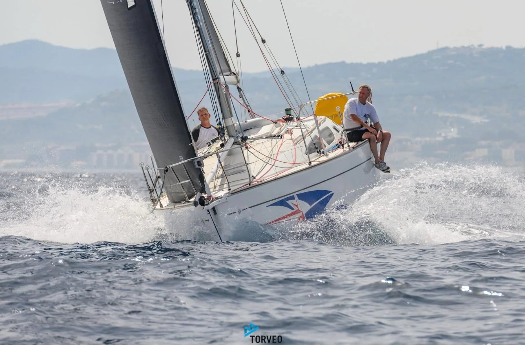 DIABOLIC, a Sun Fast 35, planing hard with spray flying off the bow