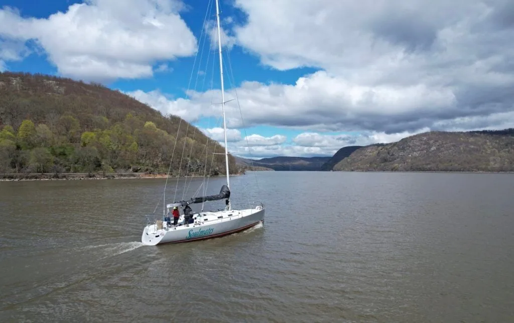 SOULMATES motoring up the Hudson River past forested hills, sails down