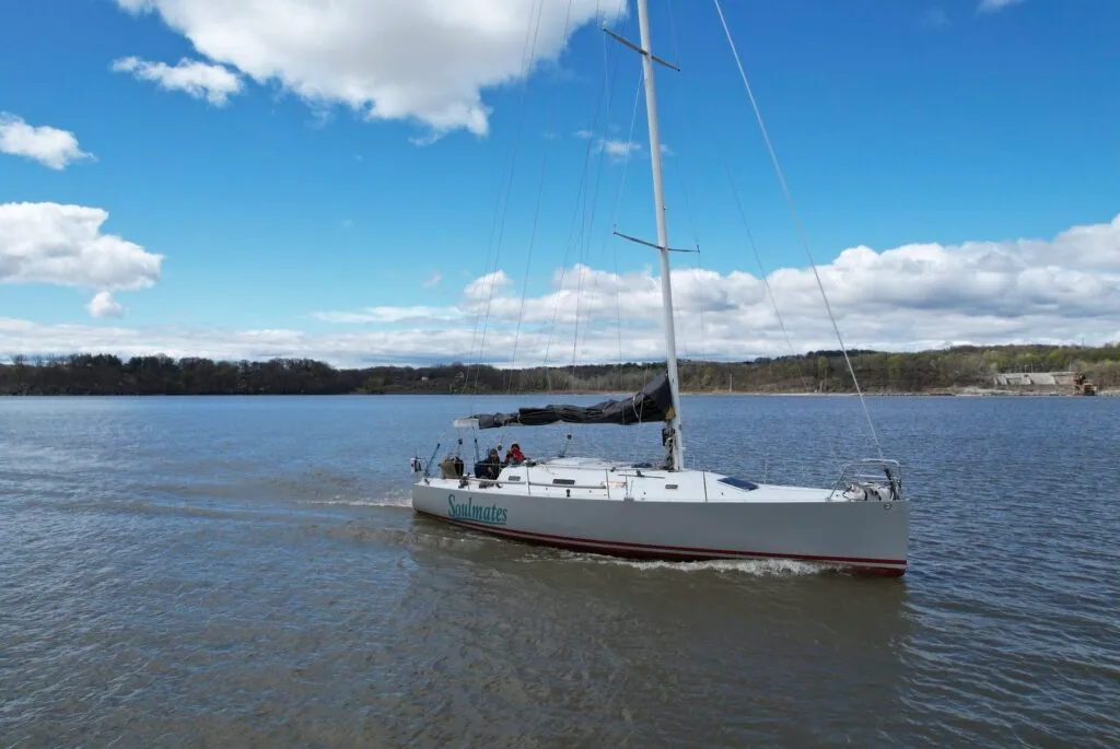 SOULMATES underway on a river with her mast bare and boom covered