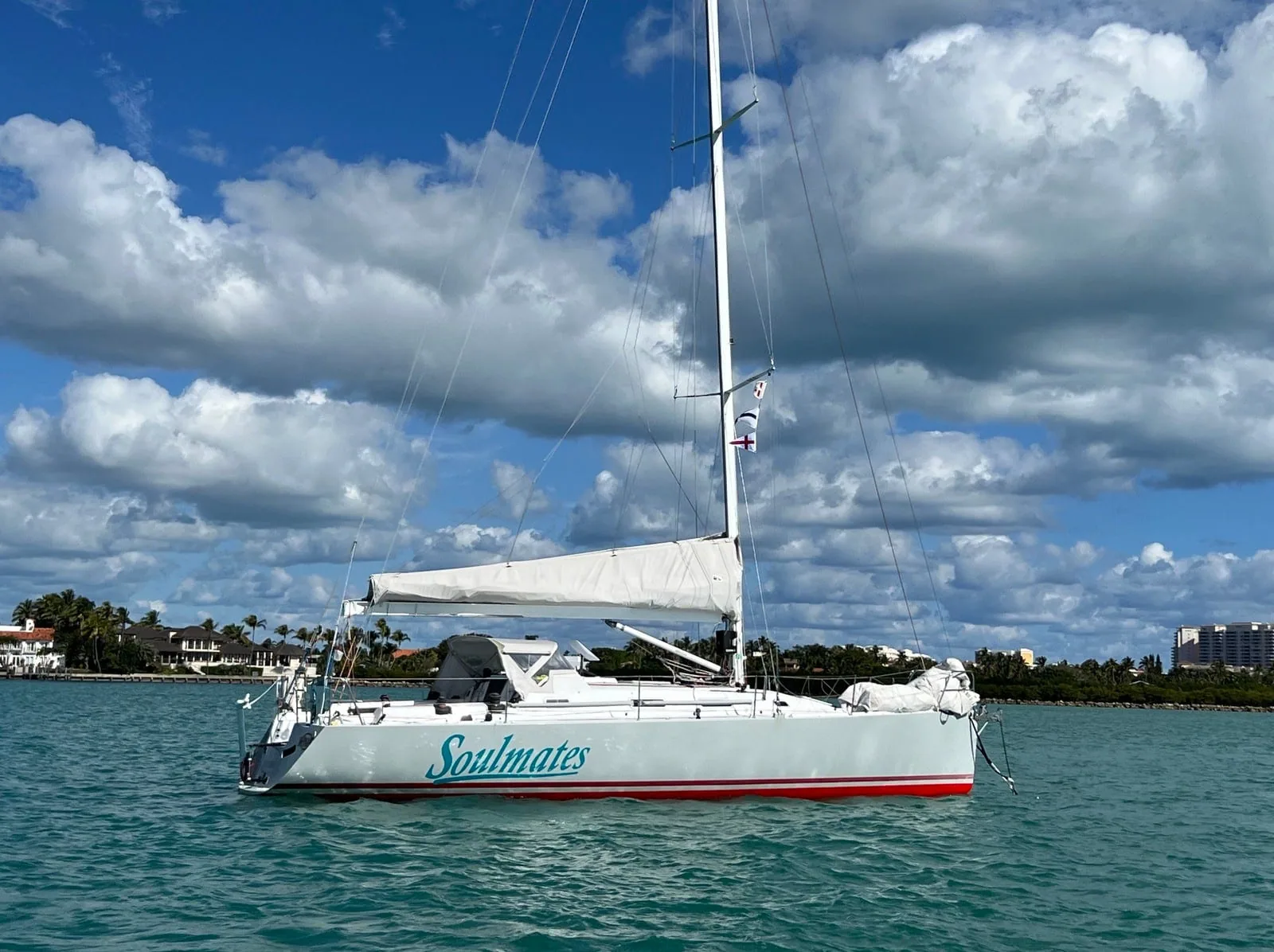 SOULMATES at anchor in turquoise water off a tropical shoreline