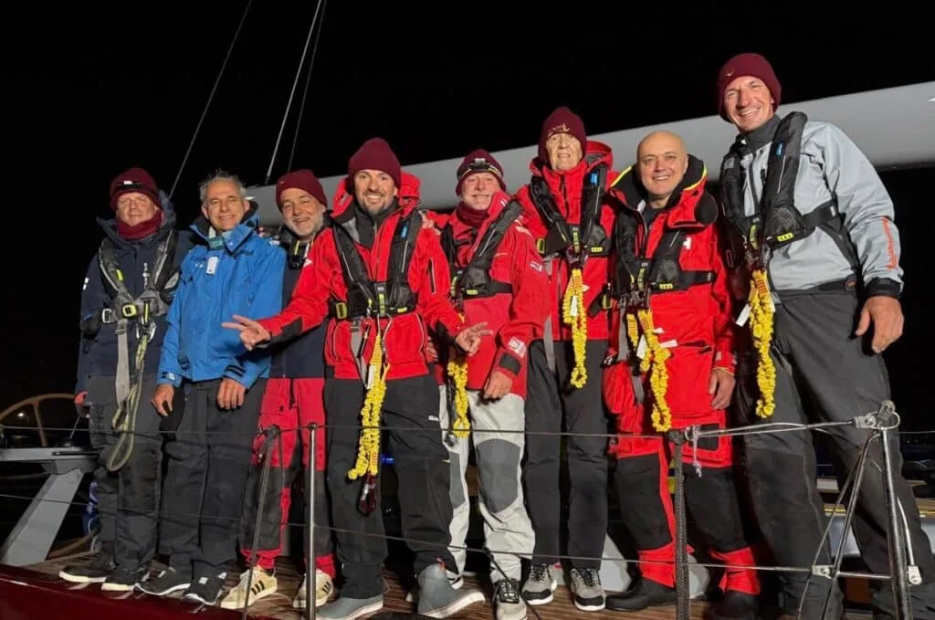 FENICE crew posing at night with leis after finishing the race