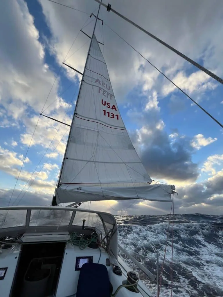 SOULMATES heeled over on a wave under sail number USA 1131 beneath a dramatic sky