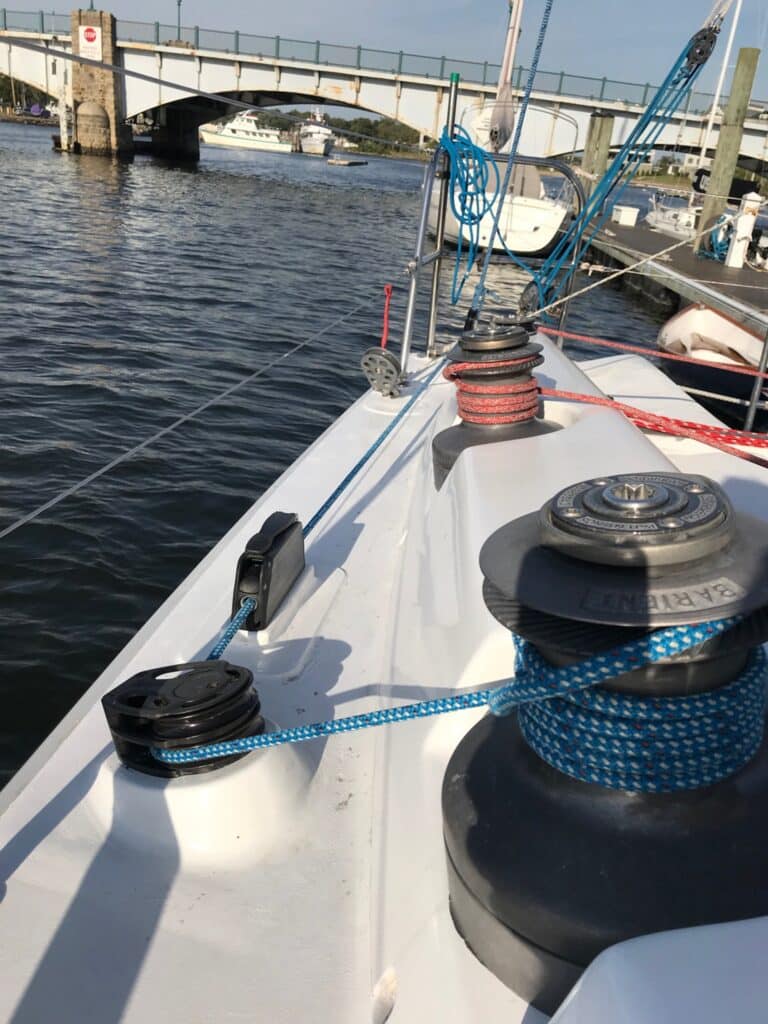 Starboard running backstay led to a deck winch, with a marina bridge in the background