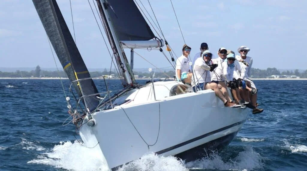 Race crew smiling on the rail while broad reaching at the 2025 Geographe Bay Race Week