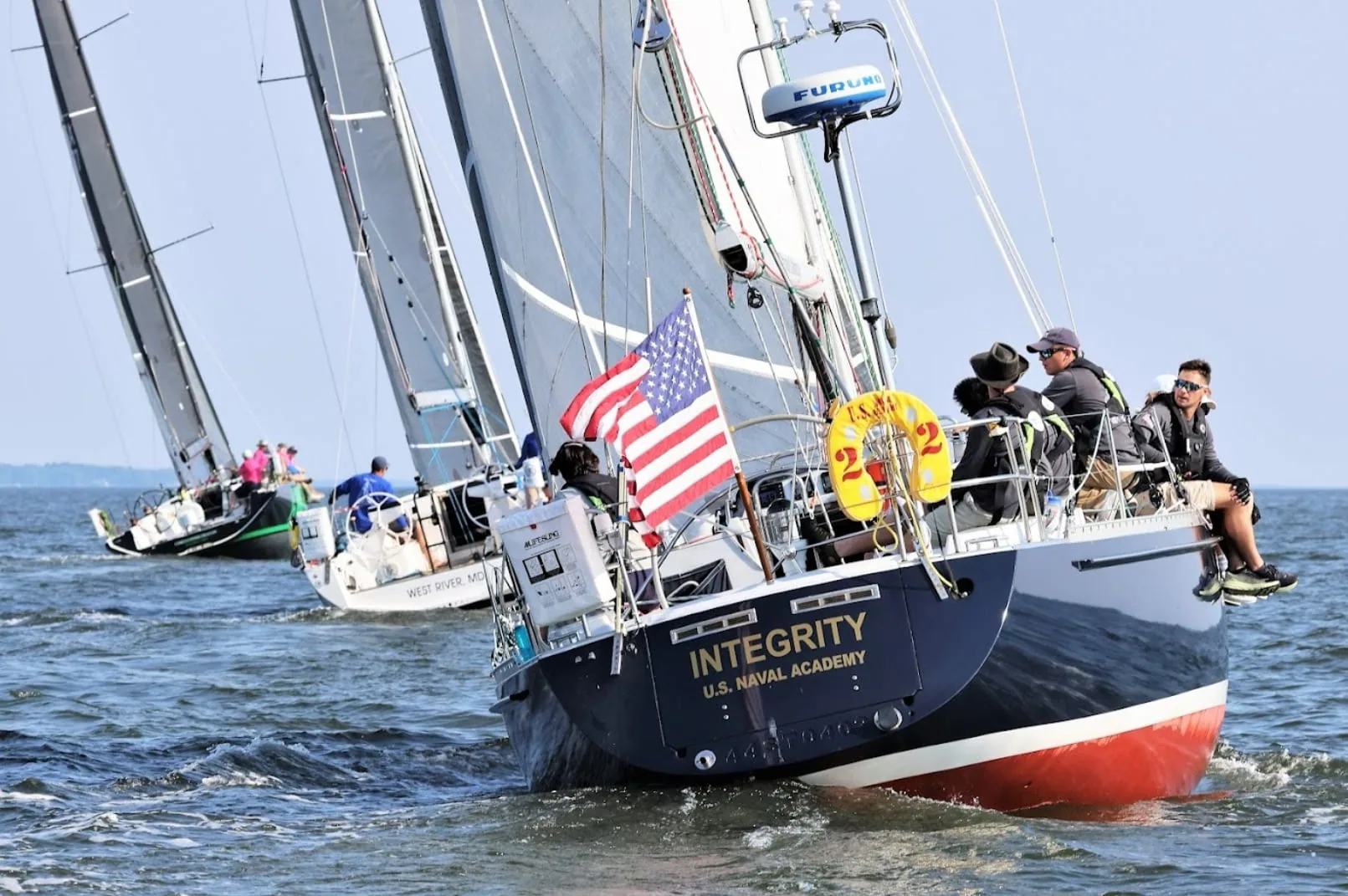 Fleet at a distance-race start, INTEGRITY (U.S. Naval Academy) closest with CHRISTOPHER DRAGON among the boats astern