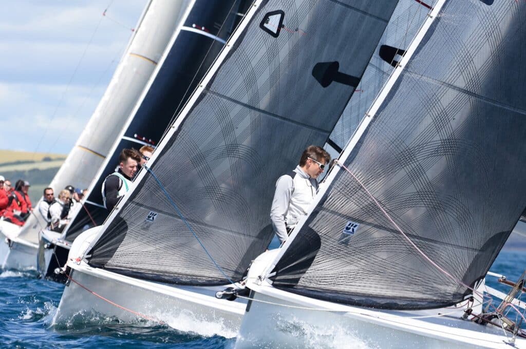 Pack of nimble 1720 one-designs jockeying tightly for position at a buoy-race start