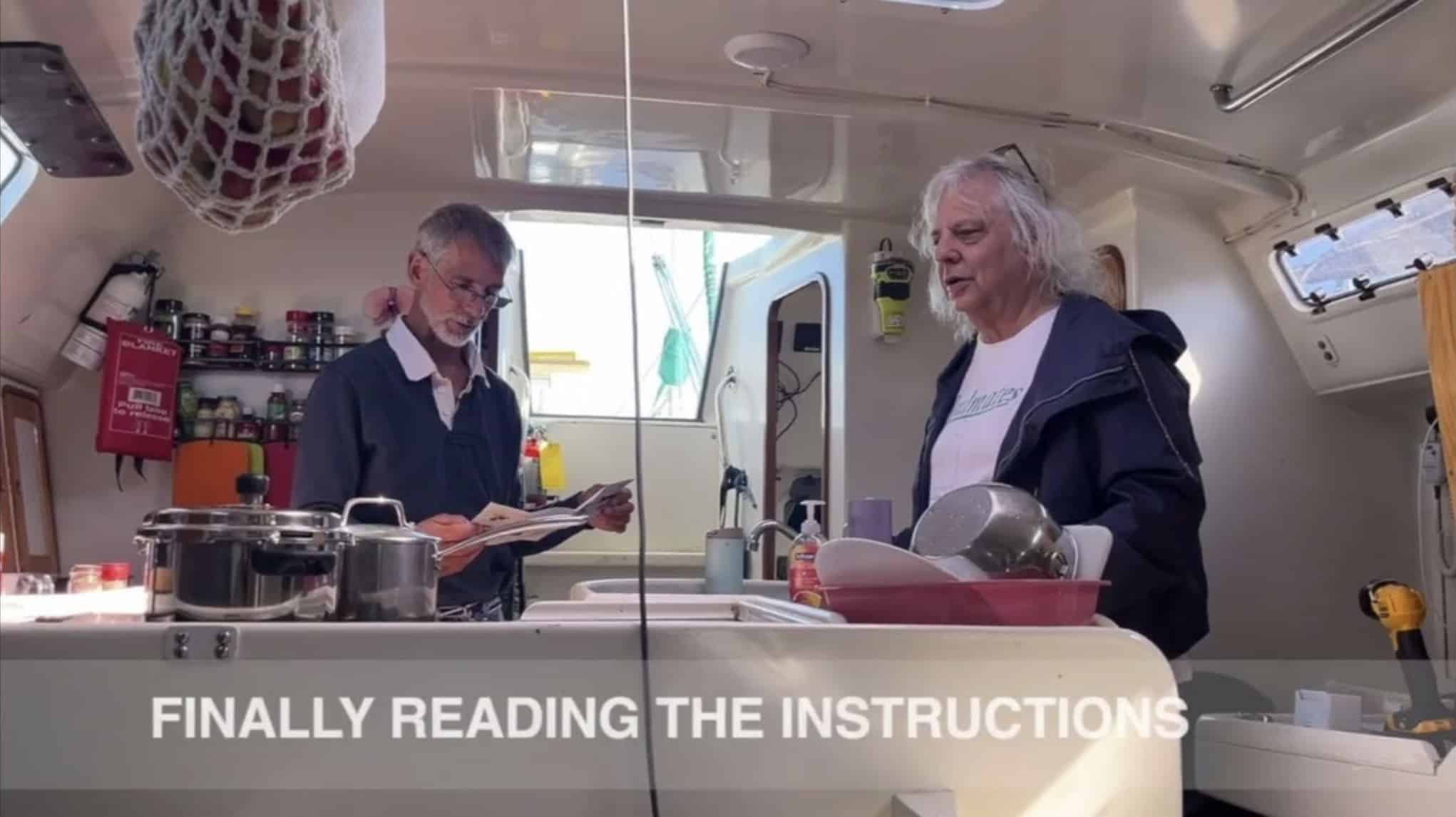 Video still of two men in a boat galley captioned "Finally reading the instructions"