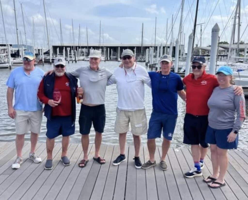 Seven sailors posing together on a dock after the J/105 Invitational
