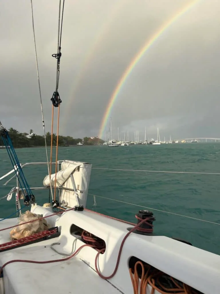 Double rainbow over a crowded anchorage, seen from a boat's foredeck