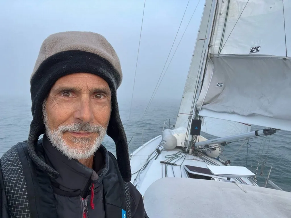 Sailor's selfie on deck with the mainsail up in thick fog