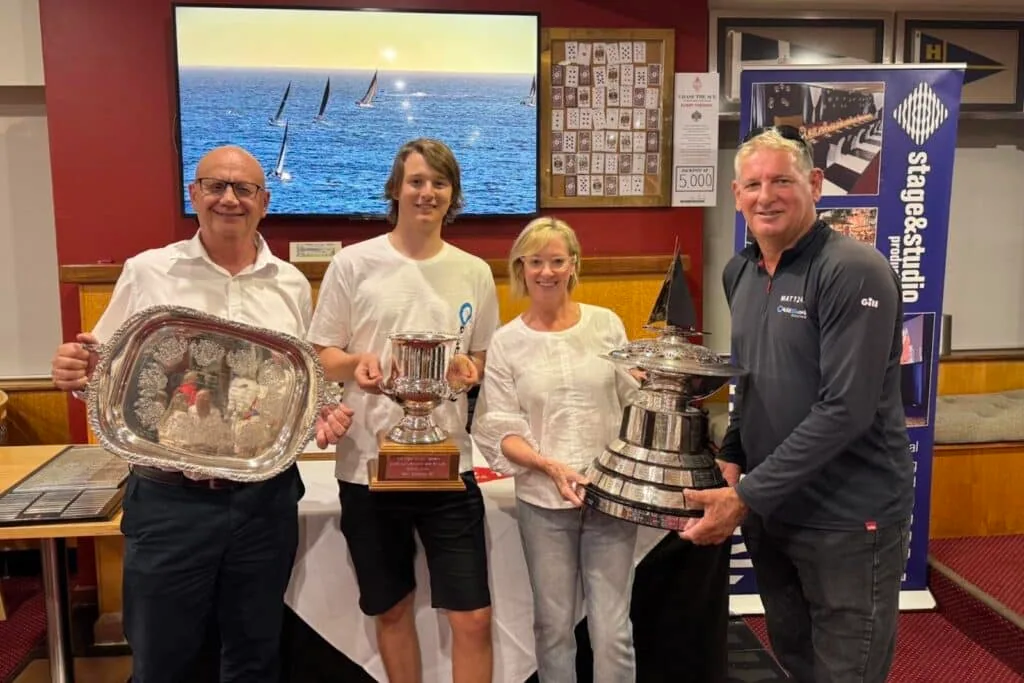 Four sailors pose with trophies at an offshore race prize-giving