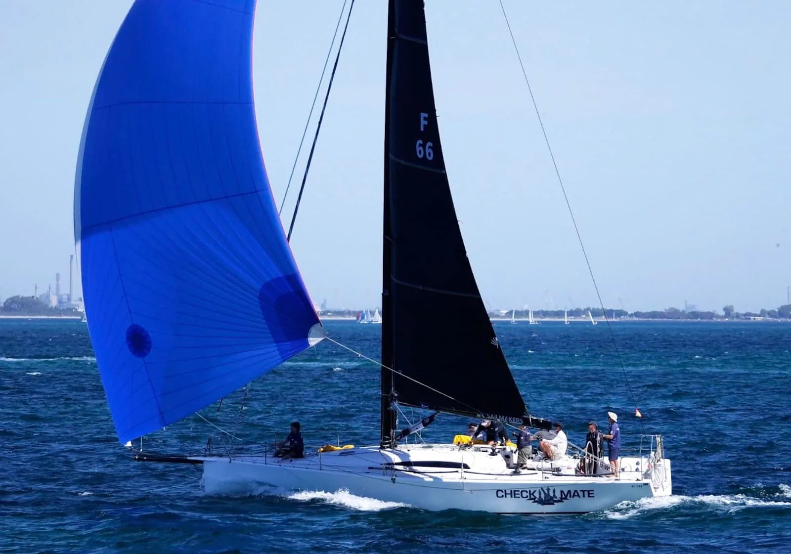 King 40 Check Mate reaching hard under a black mainsail and blue spinnaker