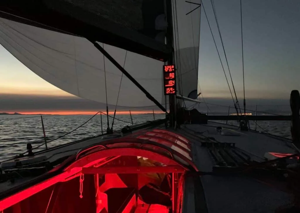 Santa Cruz 70, WESTERLY, sailing in low-light conditions. Stacks of sail bags can be seen below deck, ready for the next sail change.