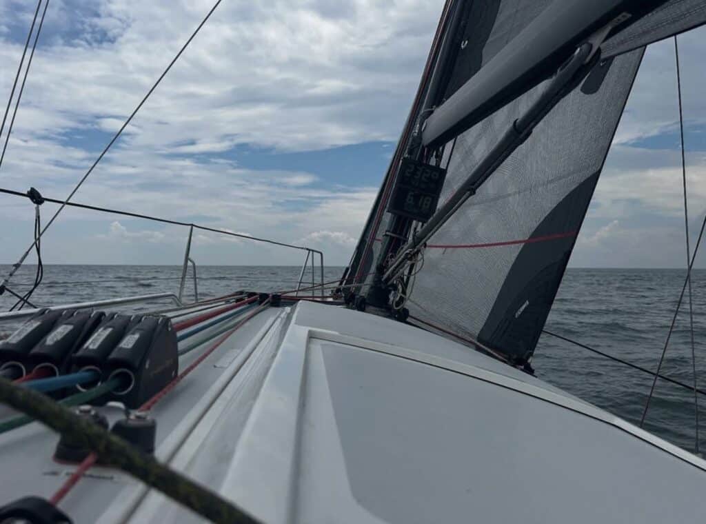 Foredeck view looking up at a grey carbon-look mainsail underway