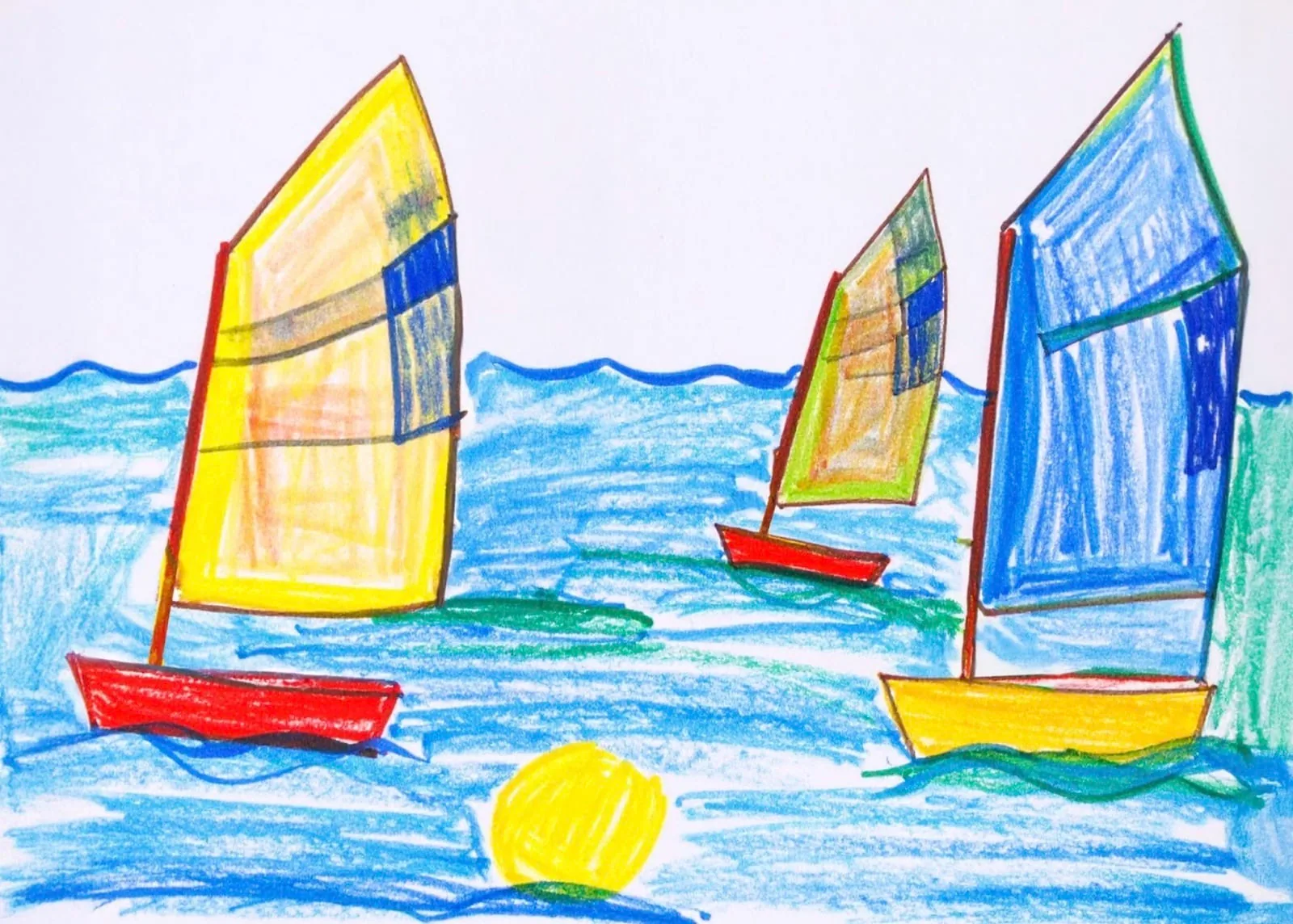Child's crayon drawing of red-hulled sailboats with yellow and blue sails and a sun