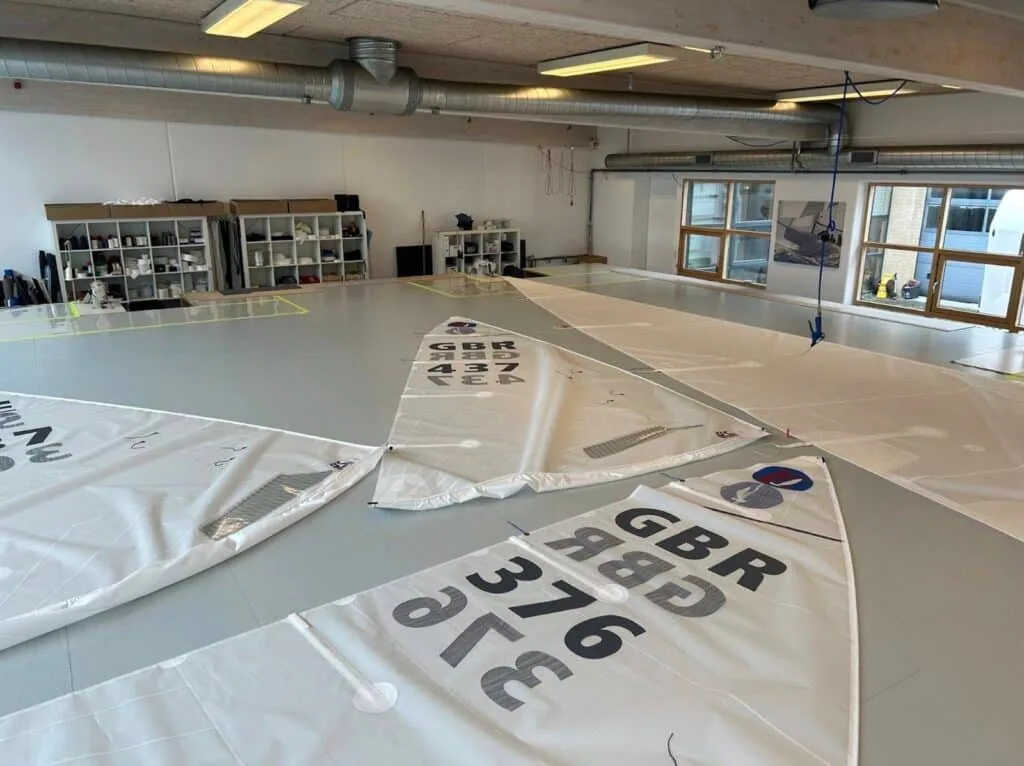 Racing dinghy sails laid out on a loft floor, numbered GBR 376 and GBR 43