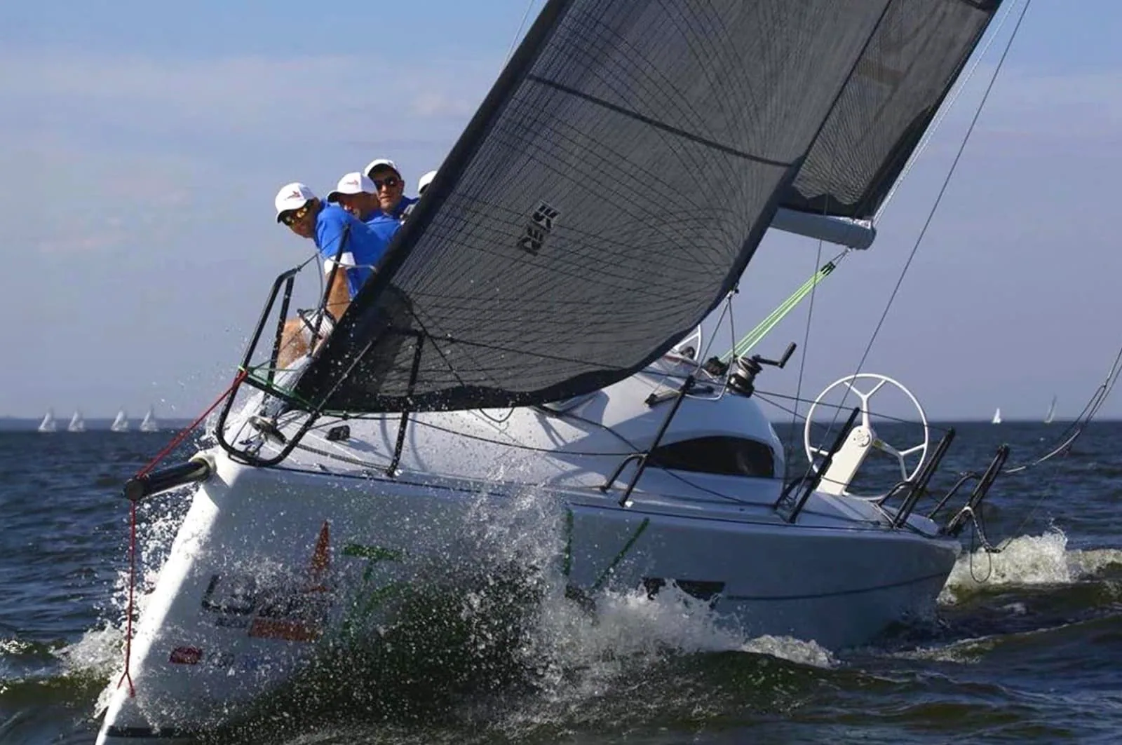 Mukhin's L30 heeled hard under white sails with crew hiking at the L30 Europeans