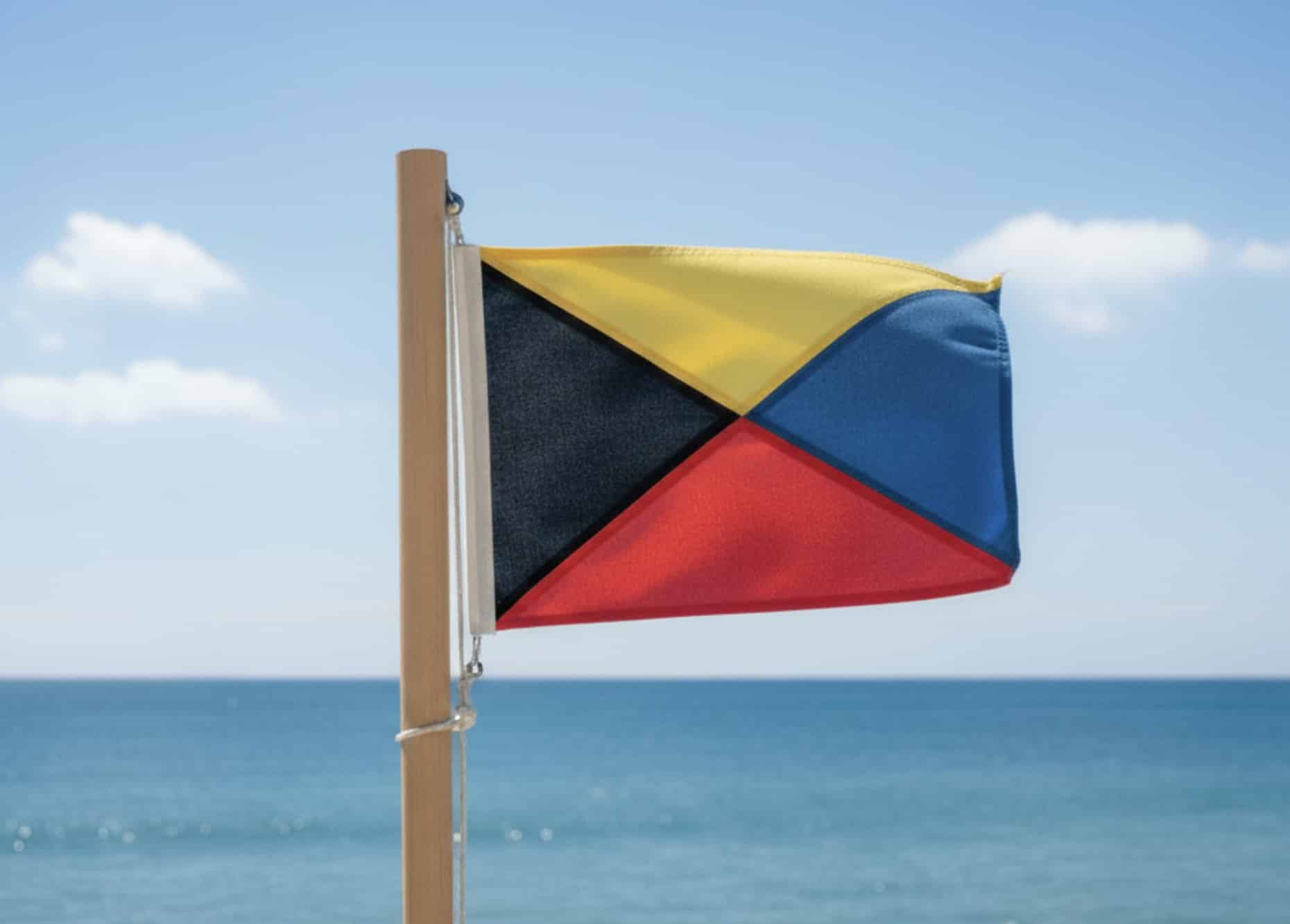 Racing signal Z flag, quartered in yellow, black, blue, and red, flying against a clear sky