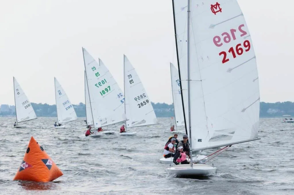 MC Scow fleet reaching past an orange mark, boat 2169 leading the pack