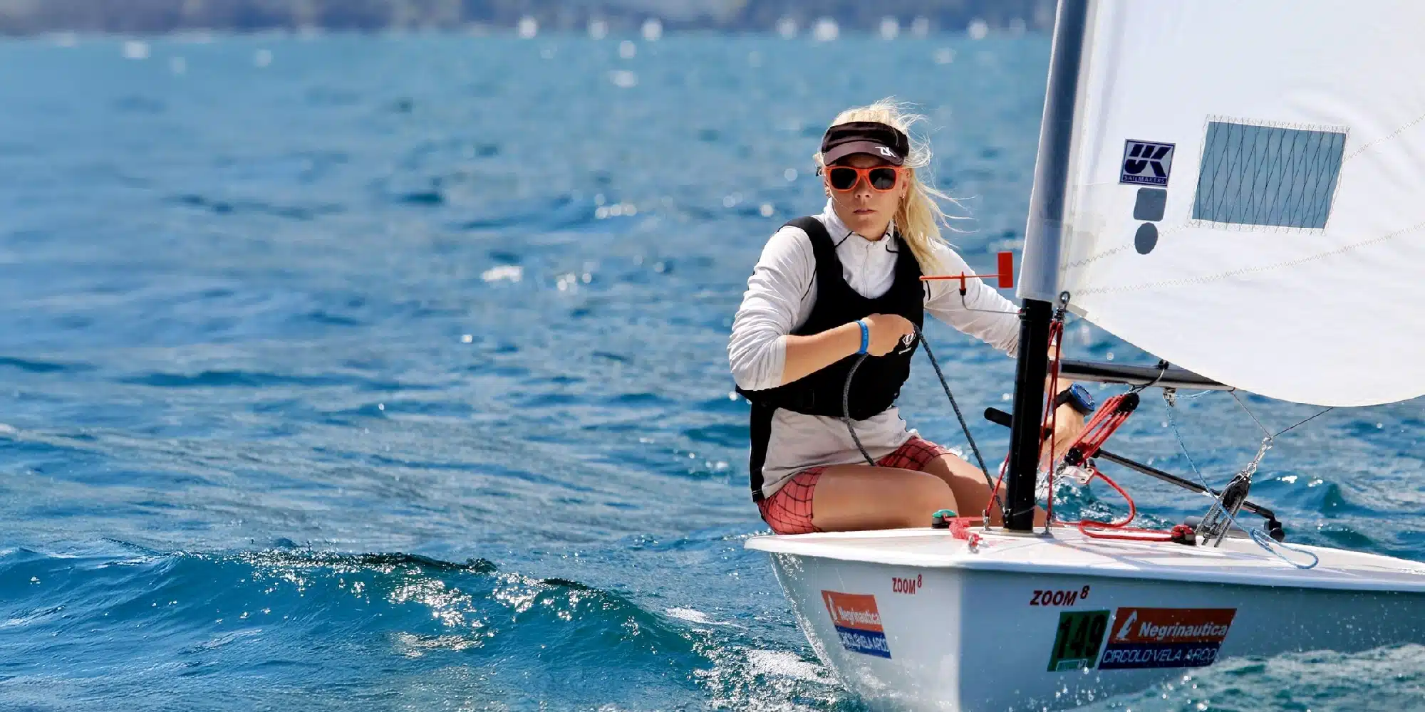 Zoom8 dinghy sailor hiking out on open water