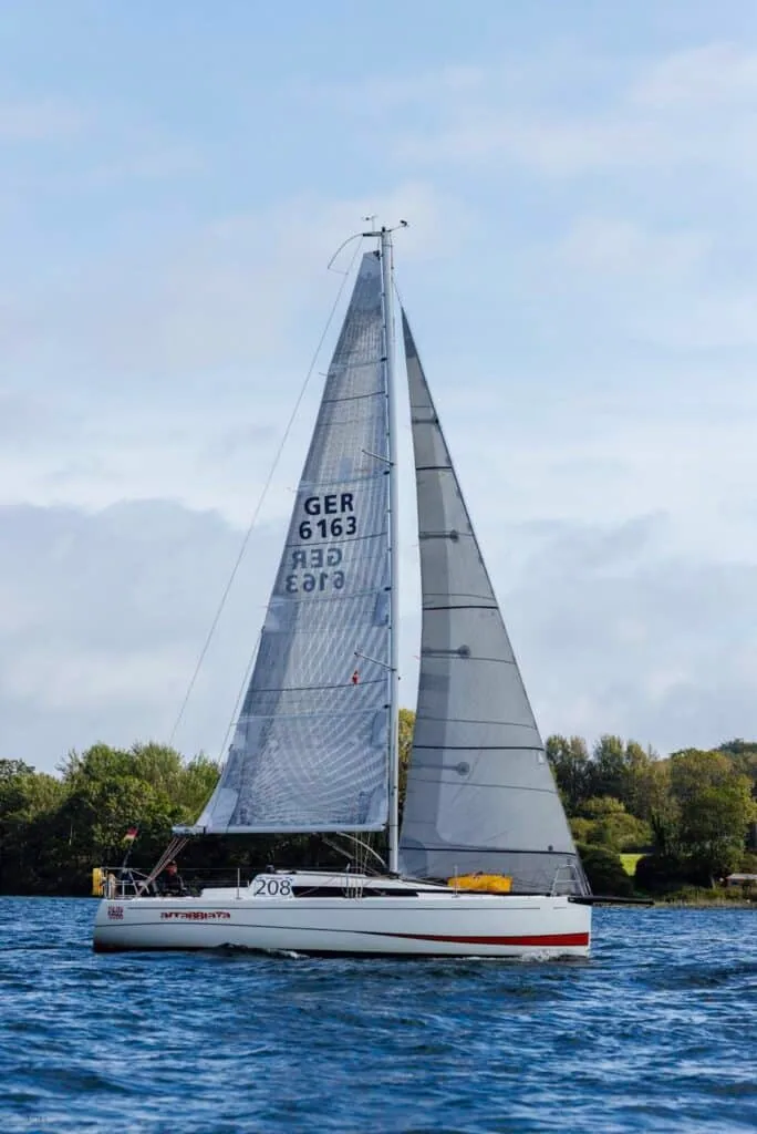Racer 208 (GER 6163) sailing close-hauled with a red boot-stripe hull in the Silverrudder fleet