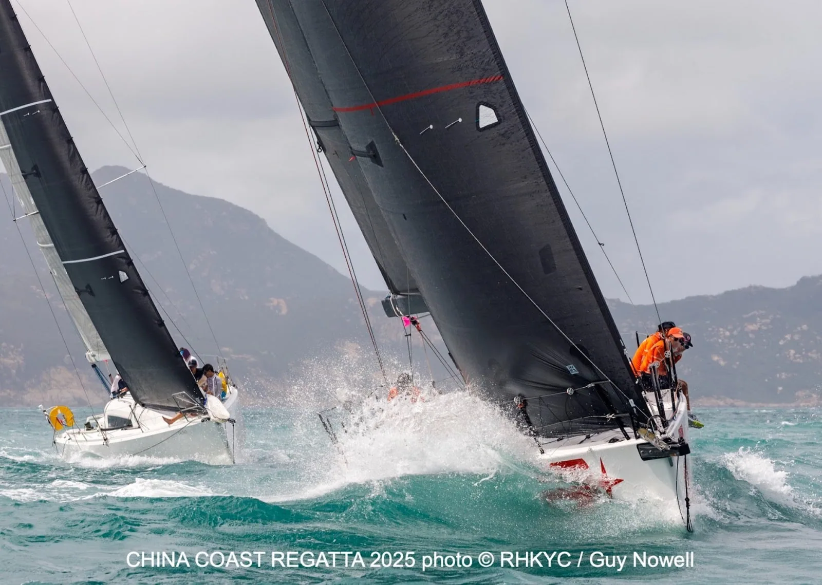 Two boats battling close upwind at the China Coast Regatta 2025, spray flying off the bow
