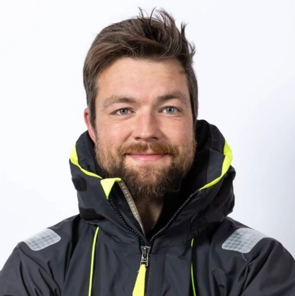 Portrait of a bearded sailor in a dark and yellow foul-weather jacket