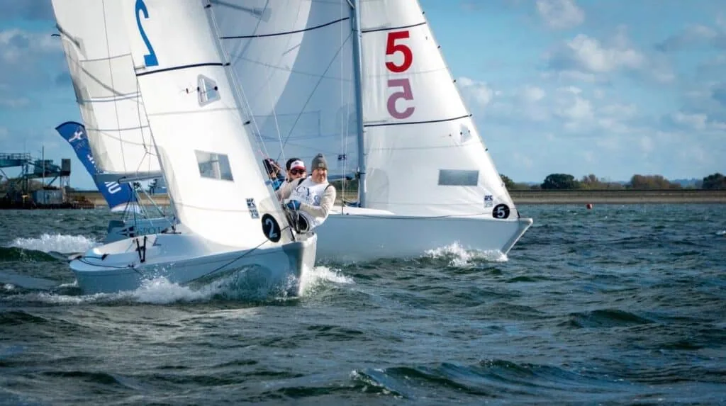 Two team-racing dinghies overlapped tightly rounding a mark