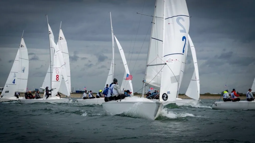 Sonar keelboat fleet close-hauled at the British American Cup, a USA flag flying from the lead boat