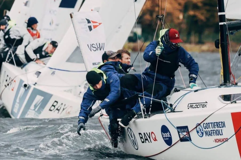 J/70 crew hiking hard as boats overlap tightly at a mark, Bundesliga Finals