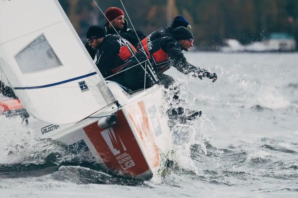 Close-up of a J/70 crew hiking hard through spray off the transom, Bundesliga Finals