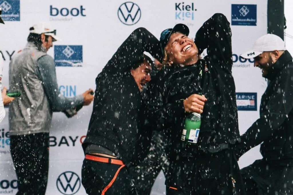 Crew celebrating with champagne spray on the podium after the Bundesliga Finals
