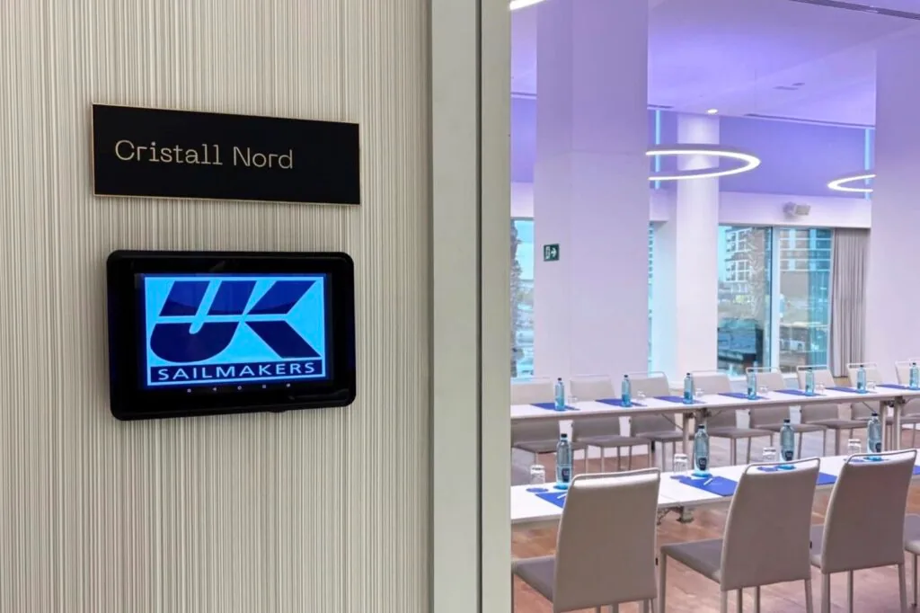 UK Sailmakers logo on a digital sign outside the 'Cristall Nord' meeting room