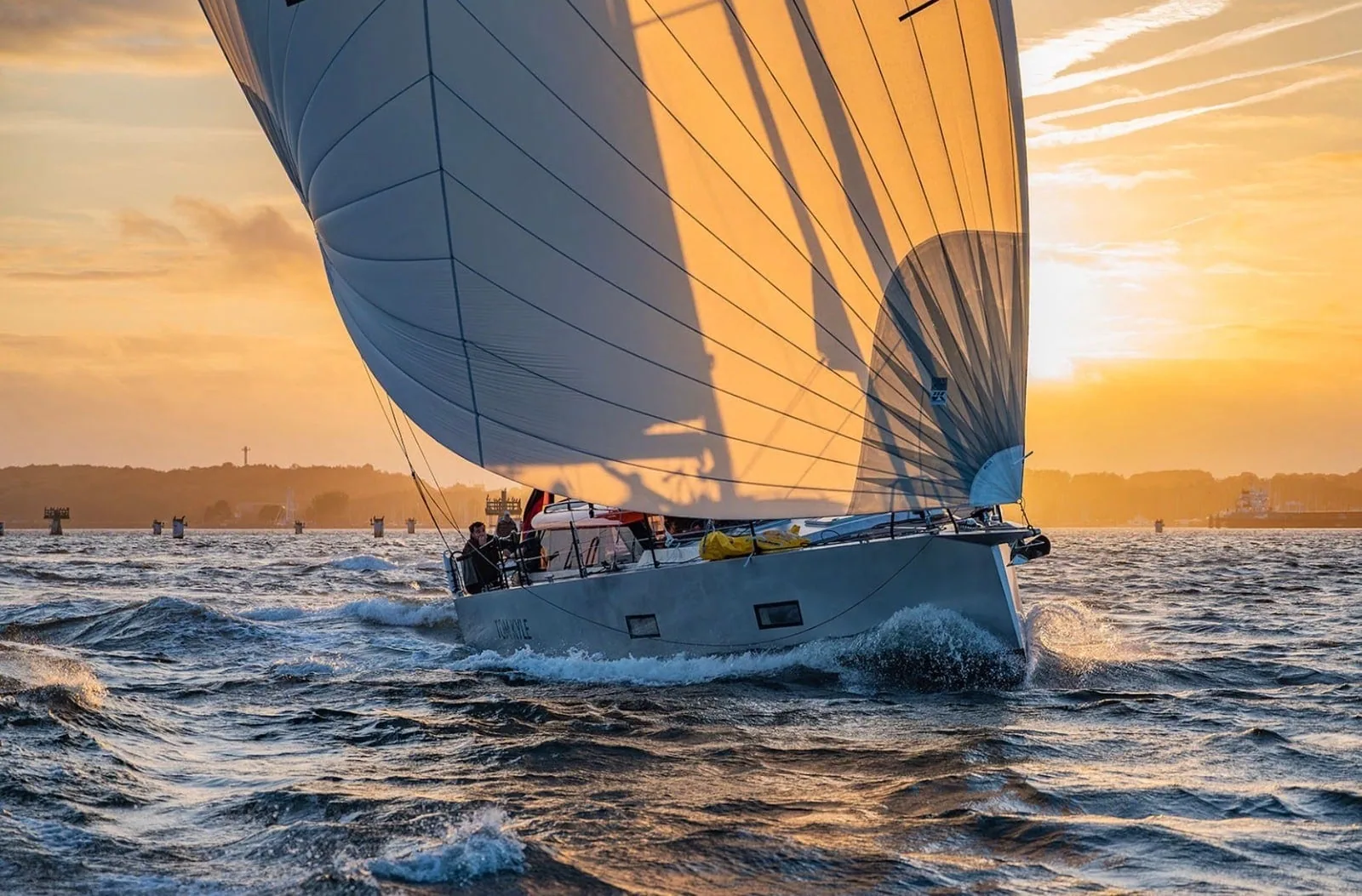 Pure 42 cruiser-racer sailing at sunset under full mainsail and jib