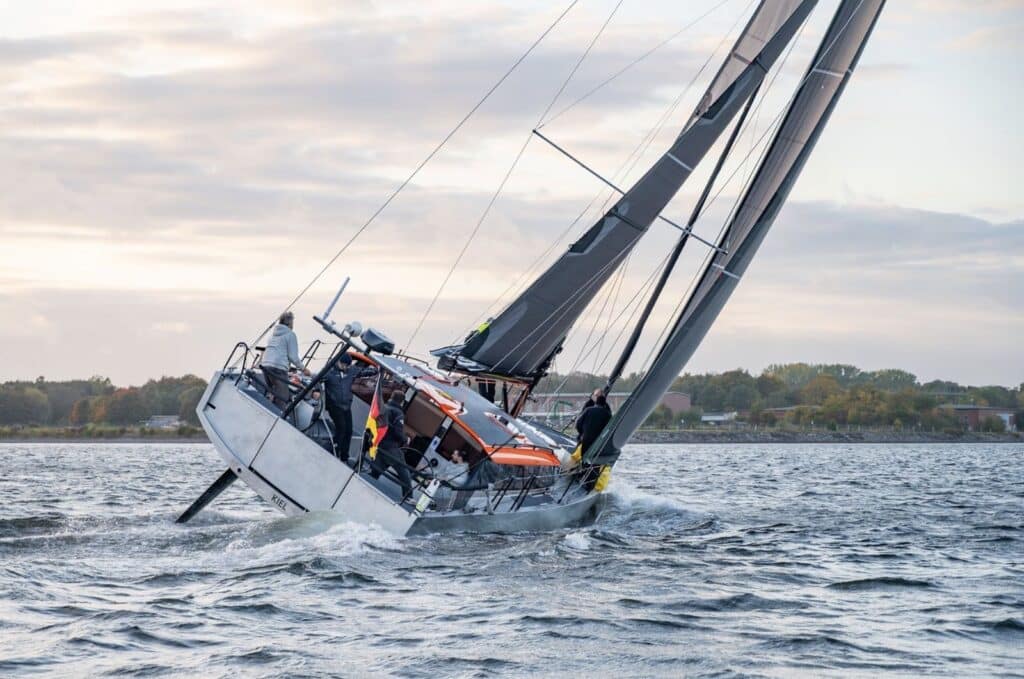 Pure 42 heeled hard under a dark X-Drive® mainsail, crew hiking on the rail