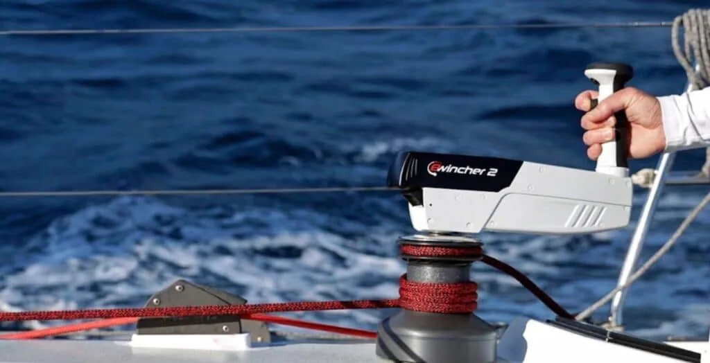 Sailor's hand gripping an Ewincher 2 electric winch handle mounted on deck