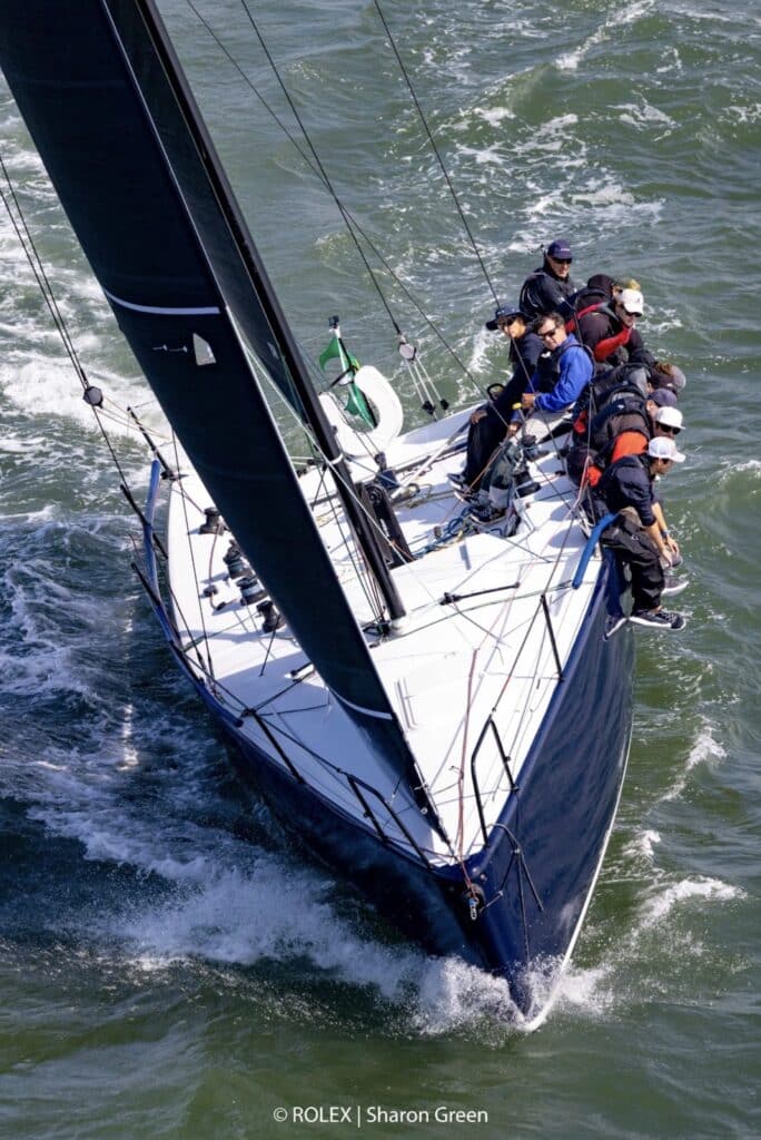Aerial view of Farr 400 Astra's cockpit with full crew hiking under a dark mainsail