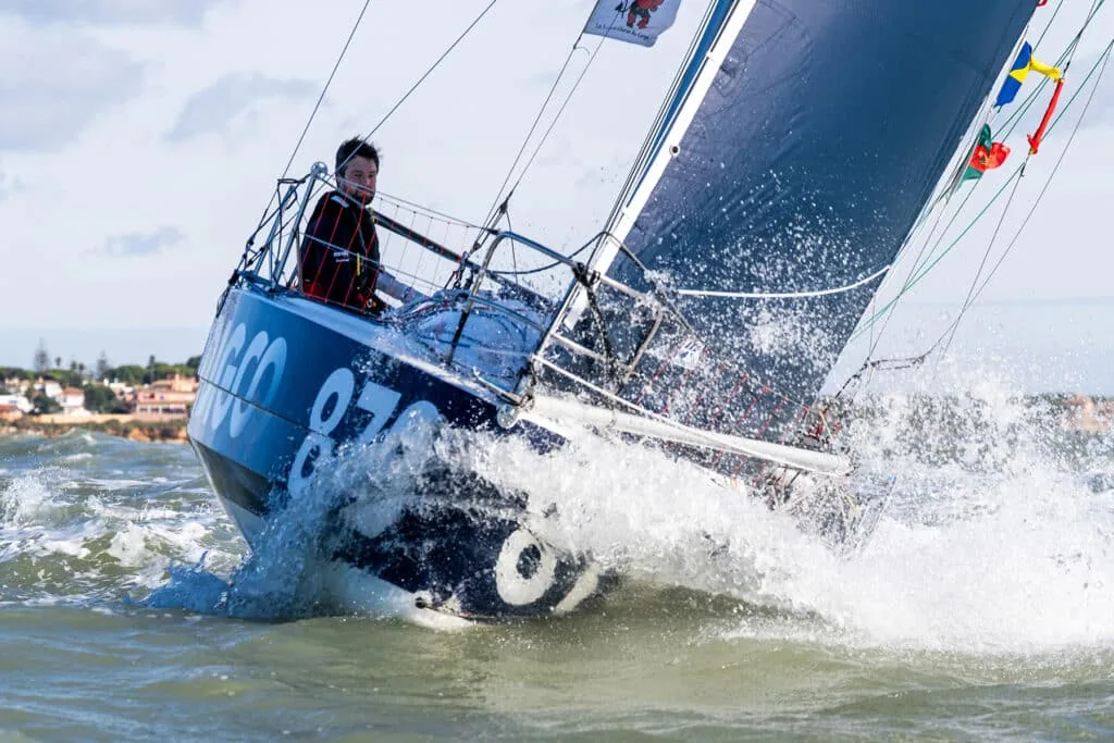 ODIGO 879 pounding through waves near shore with the solo skipper at the helm