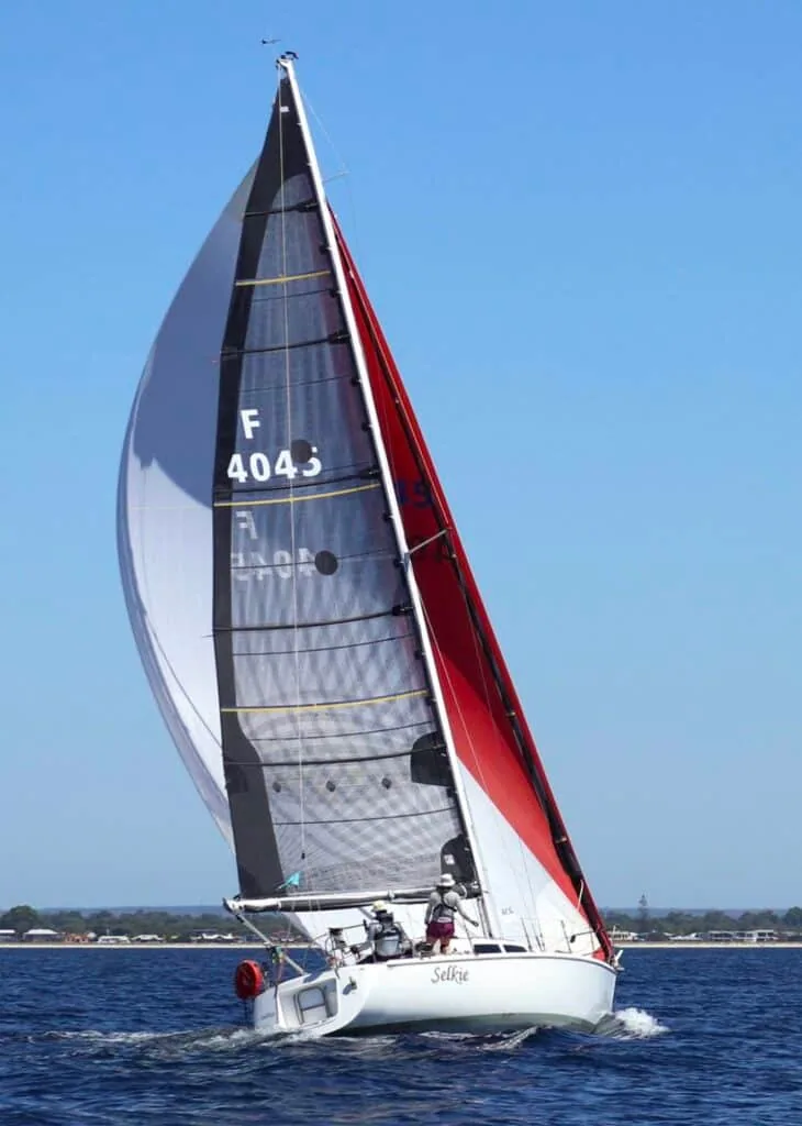 Selkie, sail F4043, close-hauled under a grey-and-red mainsail