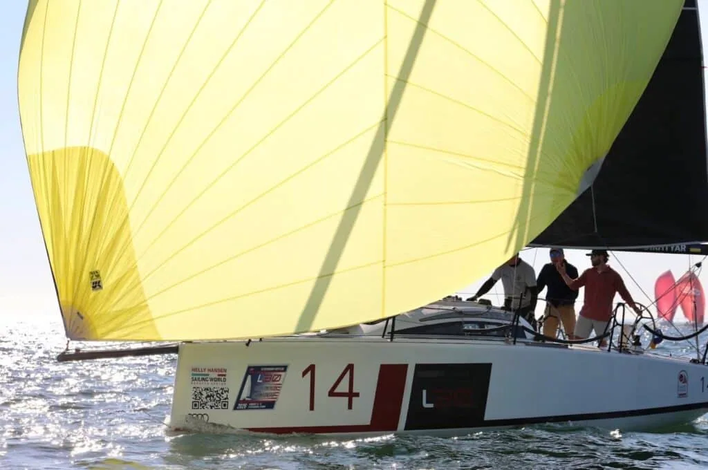 L30 #14 running downwind under a bright yellow spinnaker