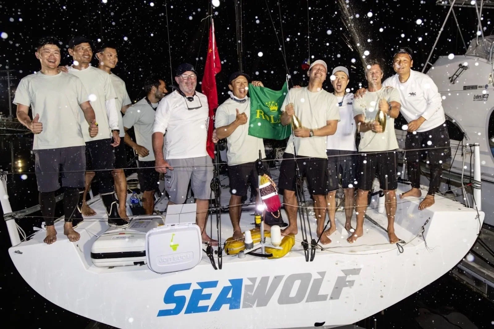 Crew of Seawolf celebrating dockside at night in the rain