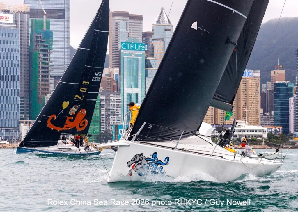 Racing yachts with dragon bow art start against the Hong Kong skyline