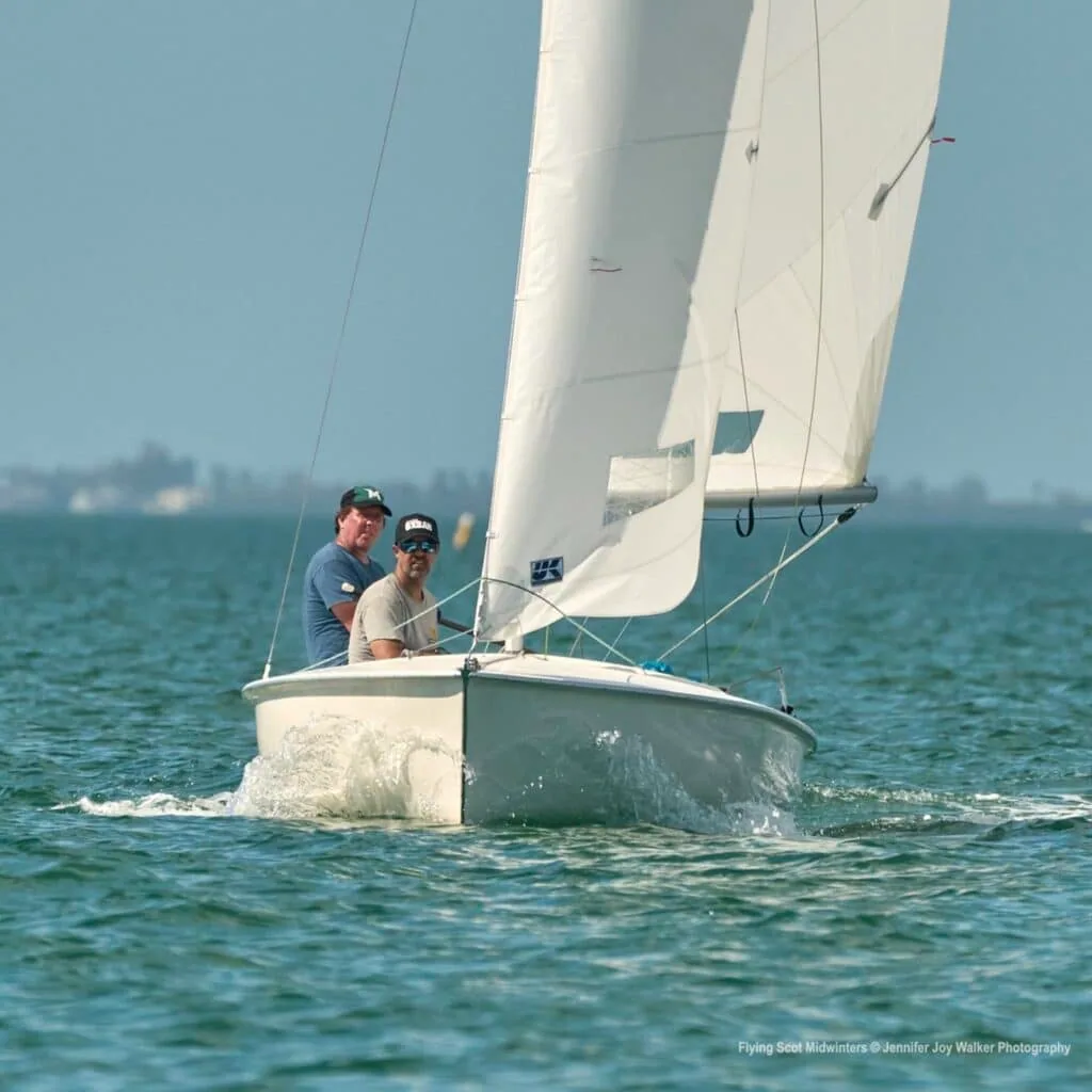 Flying Scot crew running downwind with the jib poled out