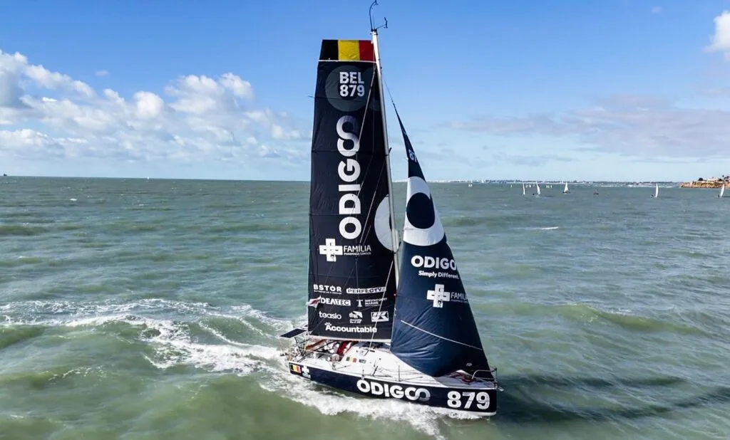 Mini 6.5 offshore racer BEL 879 reaching under sail with spray at the bow