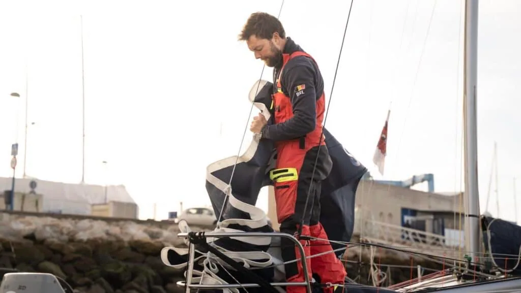 Mini 6.5 sailor coiling lines at the bow before heading out from the dock