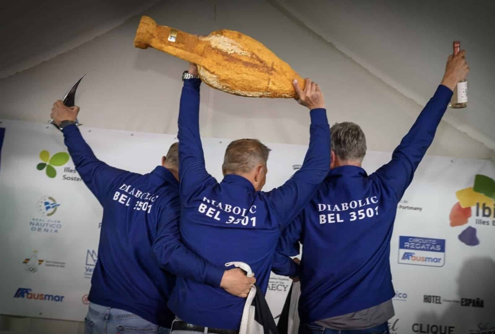 Diabolic Sailing Team celebrates on the podium holding an amphora trophy
