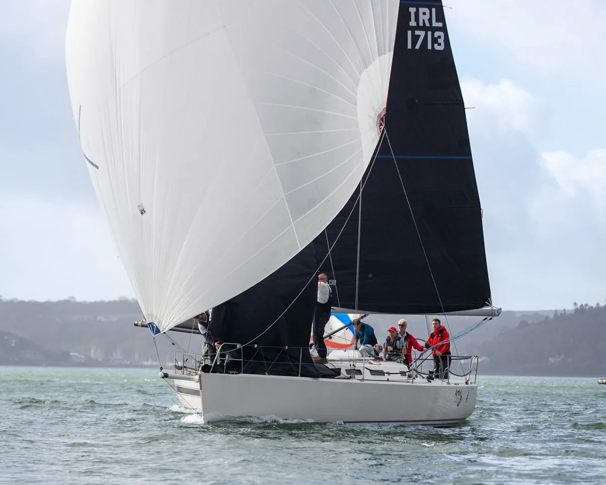 Artful DodJer running downwind under a white spinnaker, sail IRL 1713
