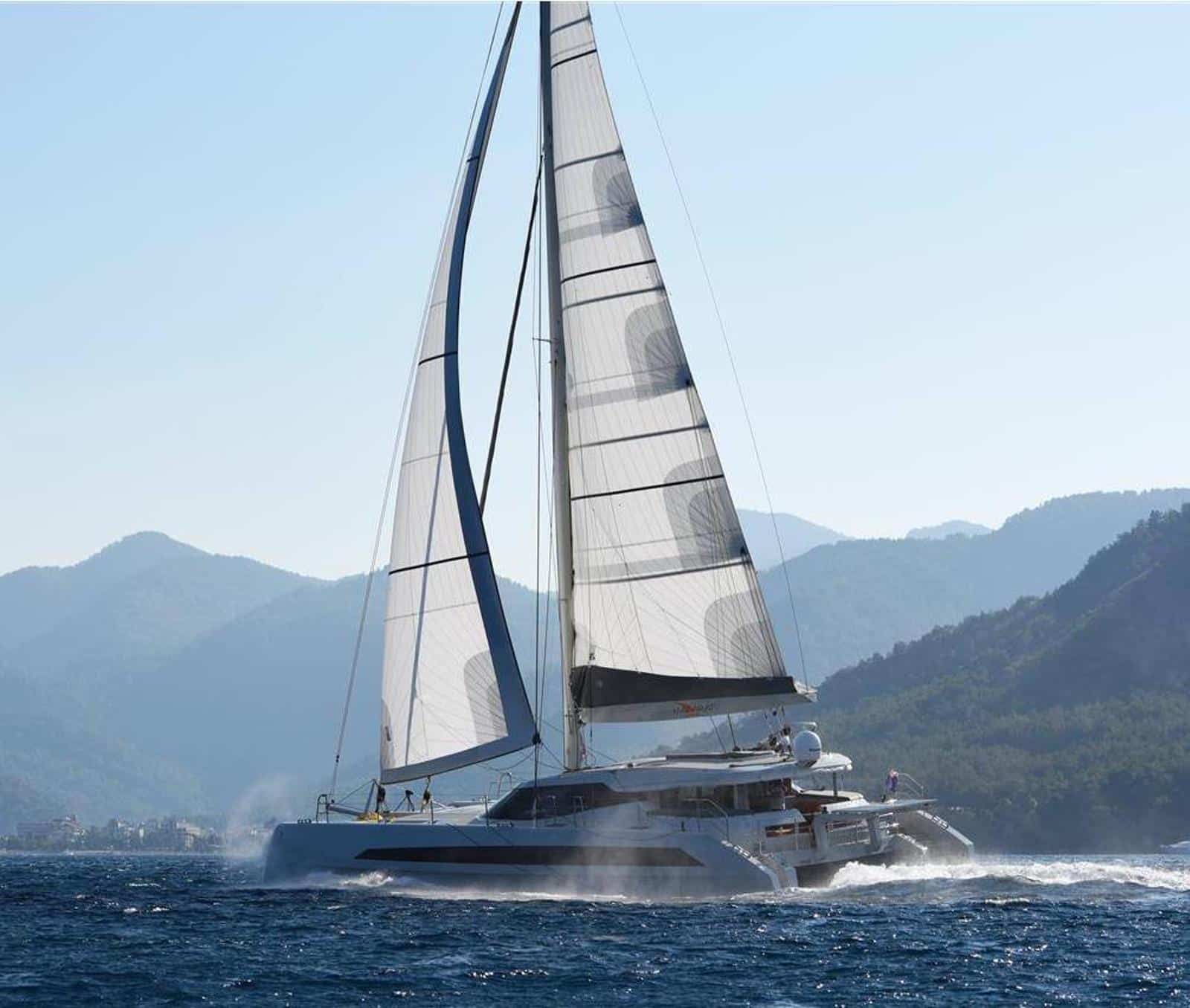 The Dubois 60 NACARAT sailing under hybrid woven sails, mountains in the background