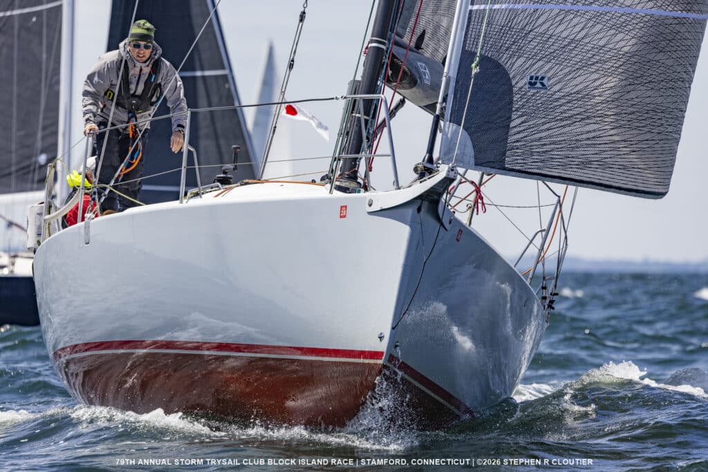 Thin Man sailing upwind with her red boot stripe cutting through waves
